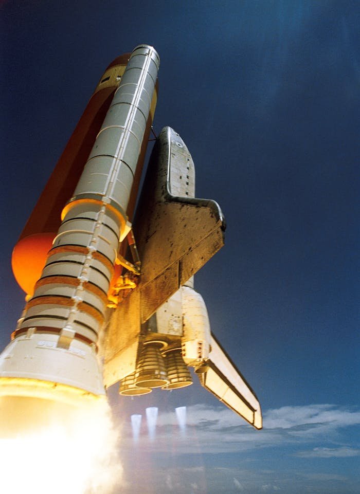 our-services-3 Dynamic low angle view of a space shuttle launch highlighting rocket boosters igniting for space travel.